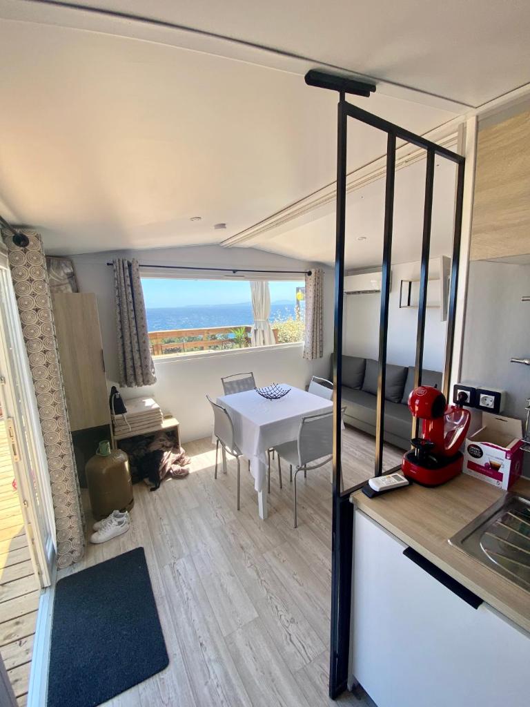d'une cuisine et d'un salon avec une table et une vue sur l'océan. dans l'établissement Mobilhome 6 places vue mer, à Drammont
