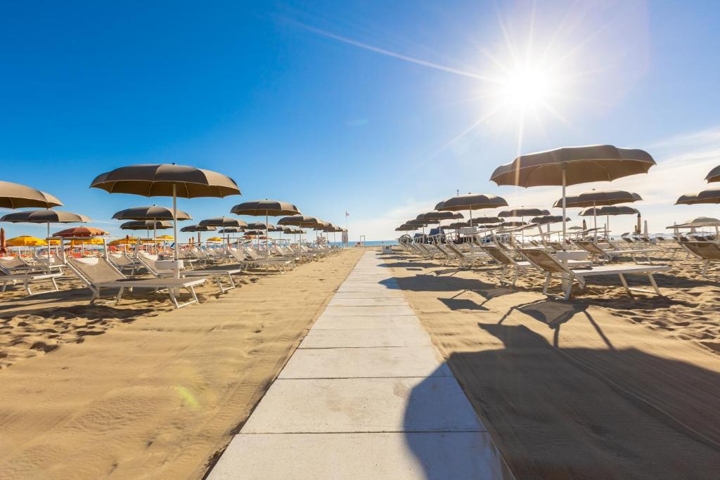 une rangée de chaises et de parasols sur une plage dans l'établissement Hotel Continental, à Rimini