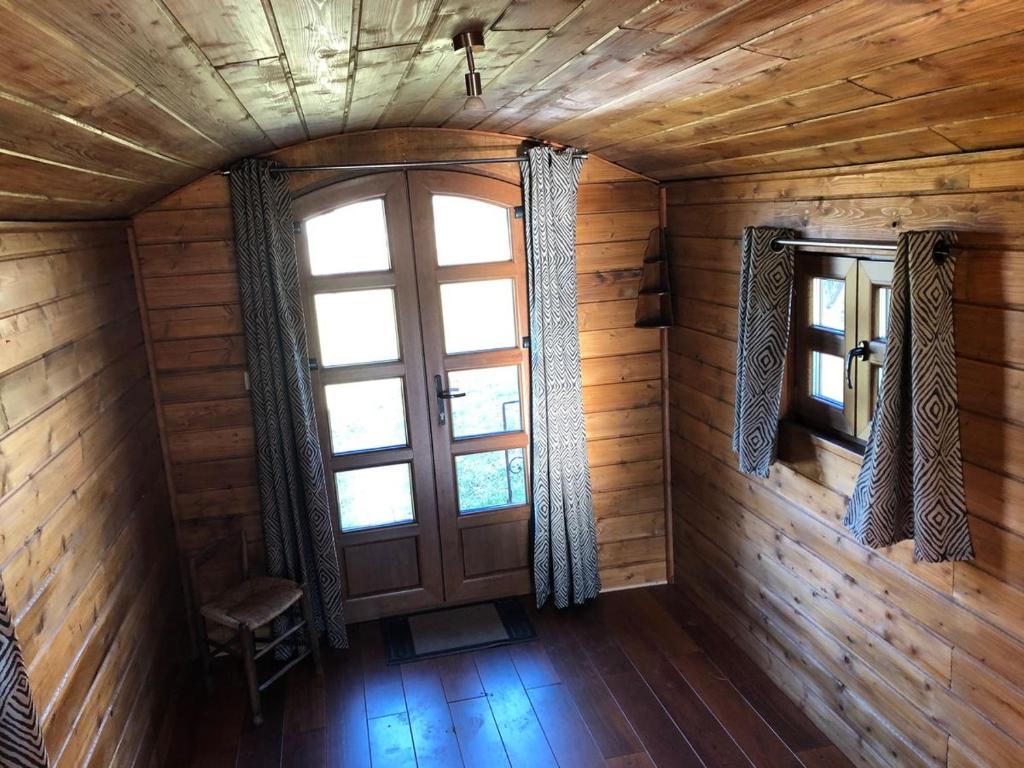 une chambre vide avec une porte et une fenêtre dans l'établissement Les roulottes de cirque Les Settons, à Moux-en-Morvan