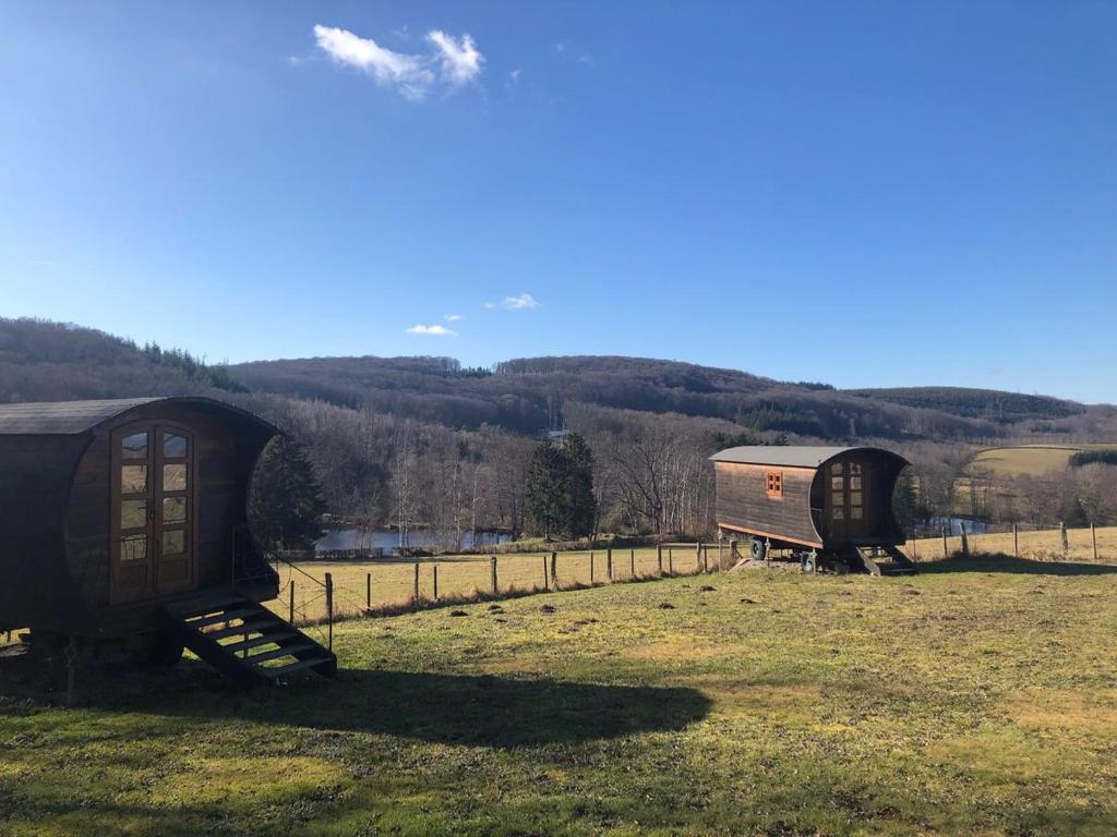 Quelques petits bâtiments assis dans un champ dans l'établissement Les roulottes de cirque Les Settons, à Moux-en-Morvan