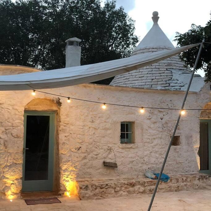 une maison en pierre dotée d'une chaîne de lumières. dans l'établissement Trulli di Charme Eutuxia, à Villa Castelli