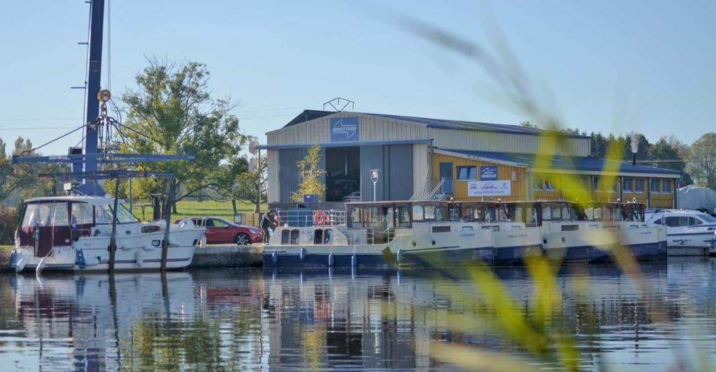 deux bateaux amarrés dans un port de plaisance comportant un bâtiment dans l'établissement Kuhnle-Tours Niderviller, à Niderviller
