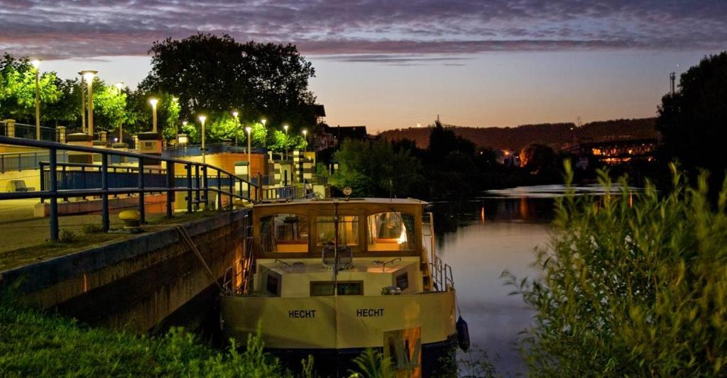 un bateau est amarré dans une rivière la nuit dans l'établissement Kuhnle-Tours Niderviller, à Niderviller