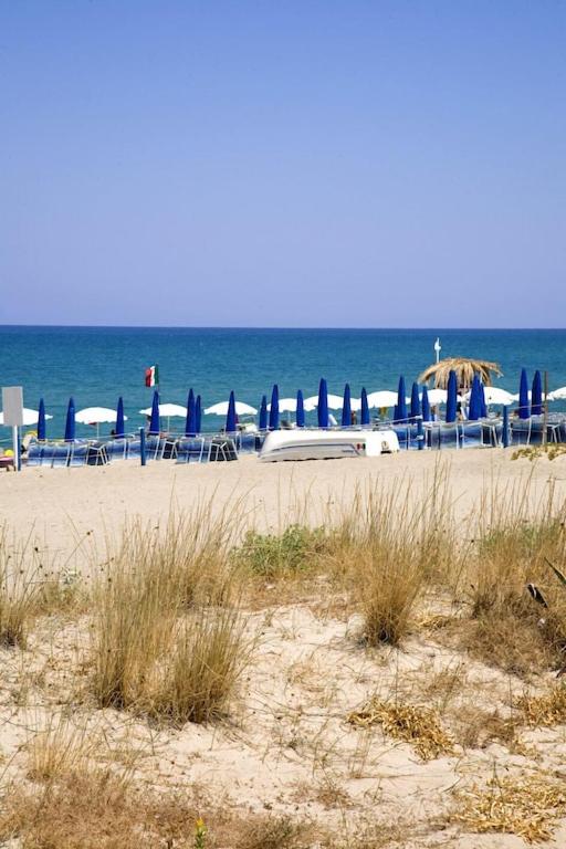 un groupe de chaises et de tables sur une plage dans l'établissement Ville dell'Eden con 9 camere da letto in 6 unità abitative, à Lascari