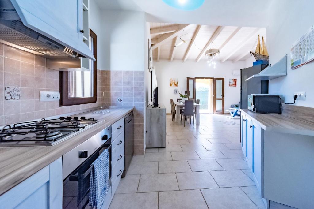 La cuisine est équipée de comptoirs blancs et de plaques de cuisson. dans l'établissement Villa Tiziana&Alessia, à Castiadas 27 autres photos