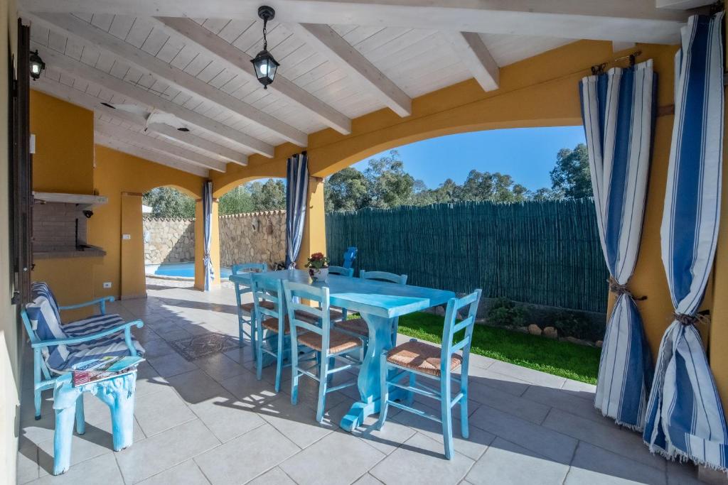 d'une terrasse avec une table et des chaises bleues. dans l'établissement Villa Tiziana&Alessia, à Castiadas