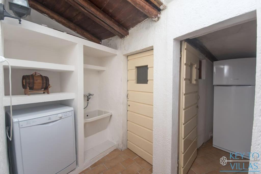 - une cuisine avec un lave-linge et un sèche-linge à côté d'une porte dans l'établissement Villa Le Filaschi - Key to Villas, à Costa Paradiso 43 autres photos