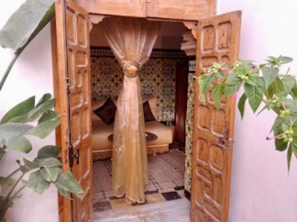- un lit dans une chambre en bois avec rideau dans l'établissement Riad El Bir, à Rabat