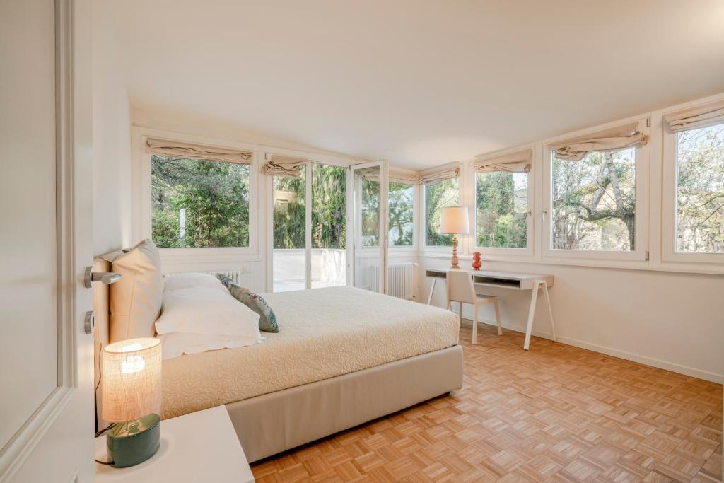 une chambre avec un lit, un bureau et des fenêtres dans l'établissement Villa dei Lauri - villa vista lago con piscina, à Salò