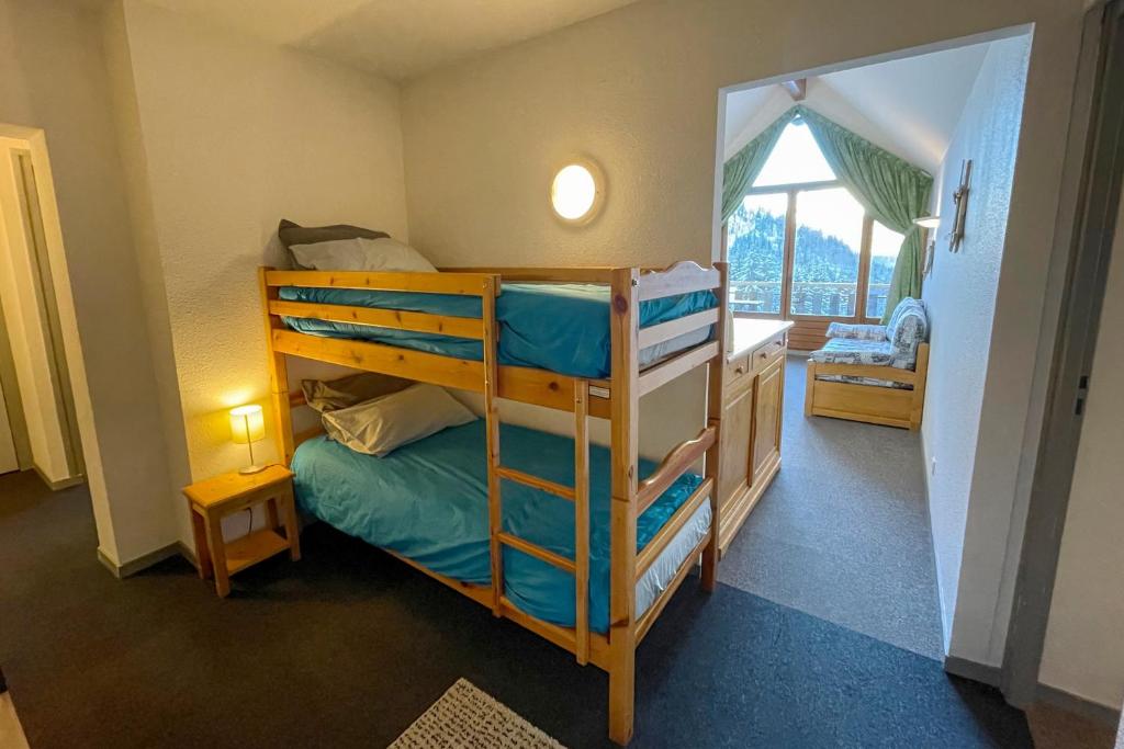 une chambre avec un lit superposé et une chambre avec une fenêtre dans l'établissement L'Alp'Oz, à Oz