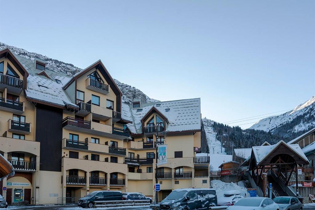 un grand bâtiment avec des voitures garées devant dans l'établissement L'Alp'Oz, à Oz