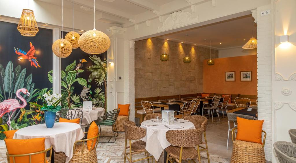 une salle à manger avec des tables, des chaises et des lumières dans l'établissement Hotel Smeraldo, à Lido di Jesolo