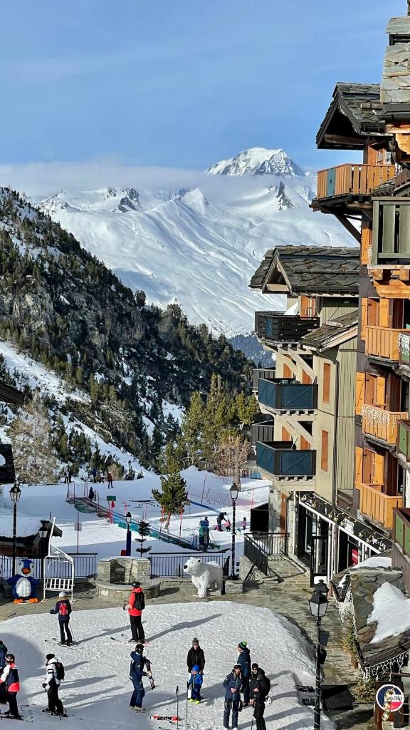un groupe de personnes à skis dans la neige dans l'établissement Arc 1950 - Appt 2CH - 6 pers - Rés 5* luxe - Piscine, sauna, hamman, jacuzzi - Classé 5 cristaux Paradiski, à Arc 1950