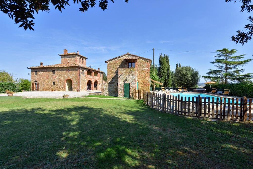 - une vue extérieure sur une maison en pierre avec une piscine dans l'établissement Casale le Rondini by VacaVilla, à Lucignano