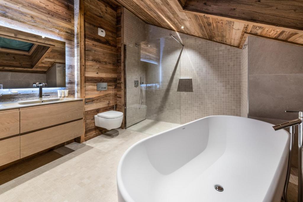 une salle de bain avec une baignoire, des toilettes et un lavabo dans l'établissement Vail Lodge by Alpine Resorts, à Val dʼIsère