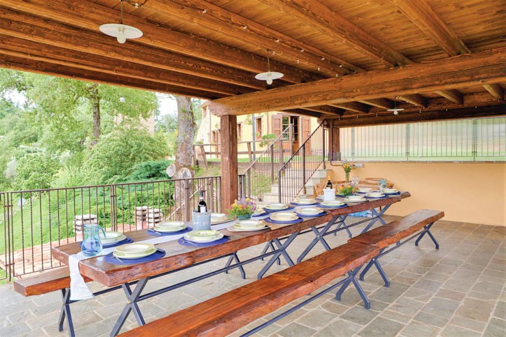 d'une longue table en bois sur une terrasse avec dans l'établissement Villa Montecastelli by Mmega, à Niccone