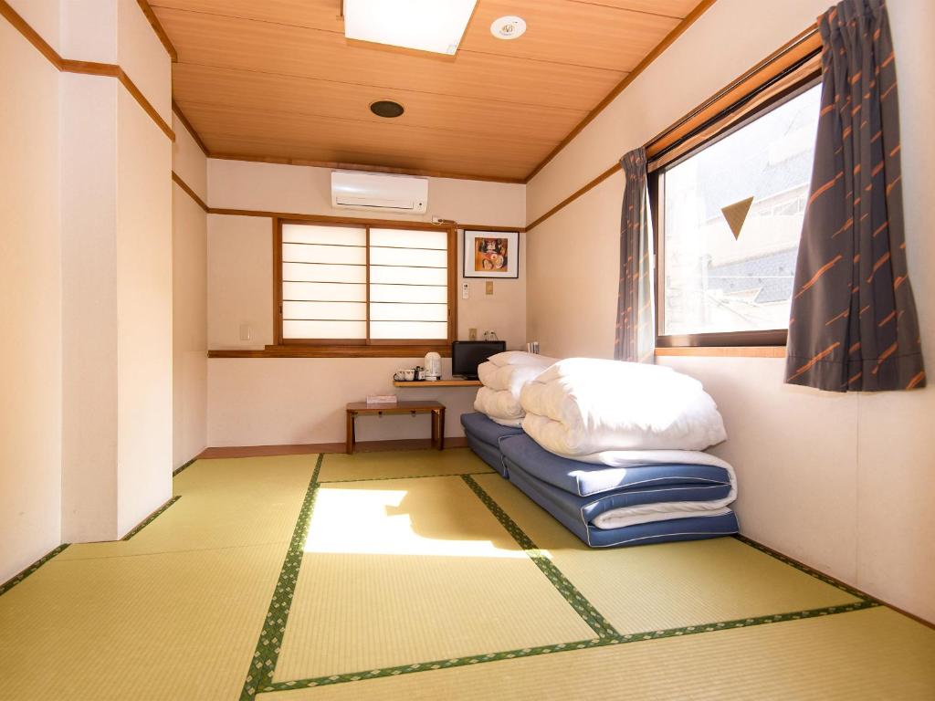 un salon avec un canapé et une fenêtre dans l'établissement Sakura Ryokan Asakusa Iriya, à Tokyo