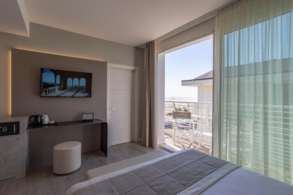 une chambre avec un lit et une grande fenêtre dans l'établissement Hotel Doriana, à Caorle