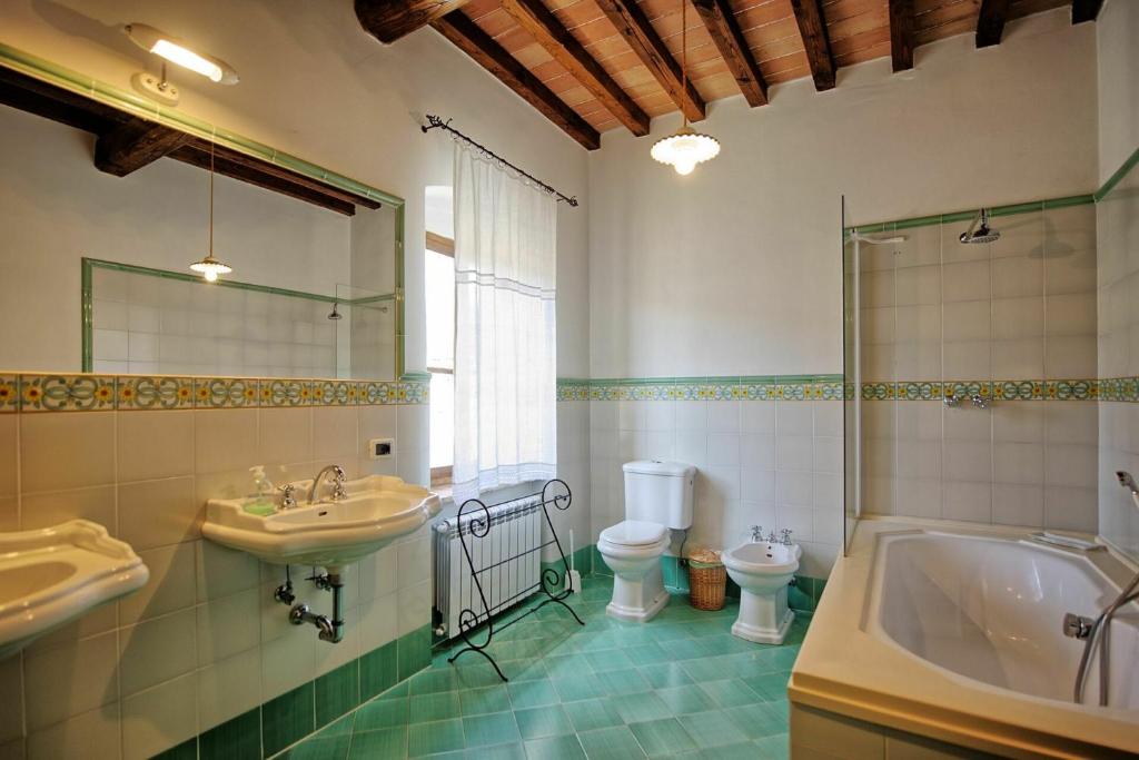une salle de bain avec un lavabo, une baignoire et des toilettes dans l'établissement Villa Capolona by PosarelliVillas, à Calbenzano