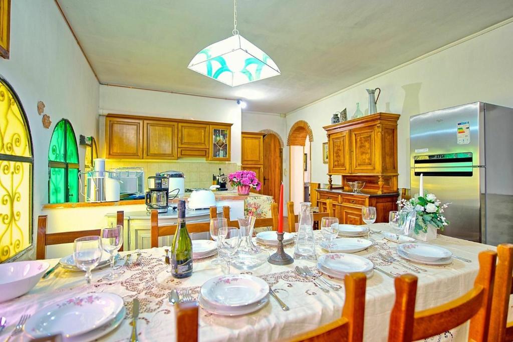 une cuisine avec une table avec des assiettes et des verres à vin dans l'établissement Villa Luciano by PosarelliVillas, à Chiassa Superiore