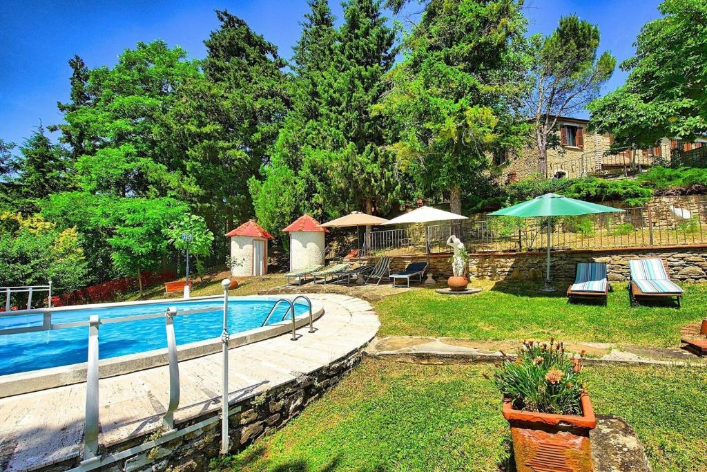 une cour arrière avec une piscine et une maison dans l'établissement Villa Luciano by PosarelliVillas, à Chiassa Superiore