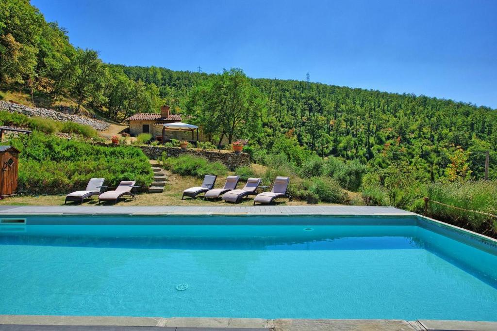 une piscine avec des chaises longues et un gazebo dans l'établissement Villa Tenuta Lonciano by PosarelliVillas, à Florence
