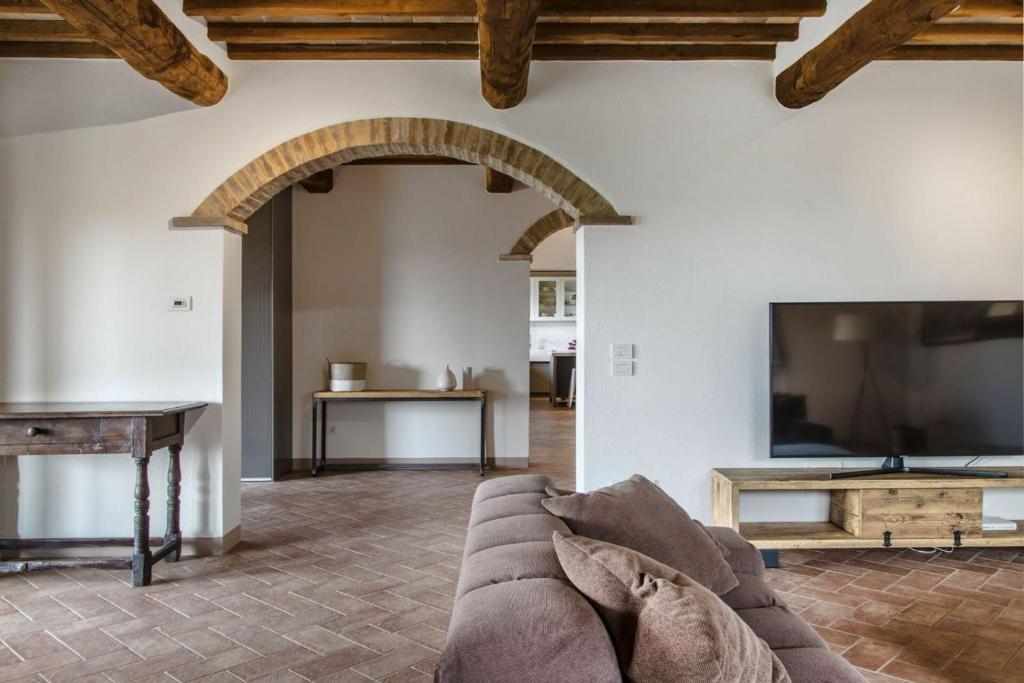 un salon avec un canapé et une télévision à écran plat dans l'établissement Villa Chiugi by PosarelliVillas, à Seggiano