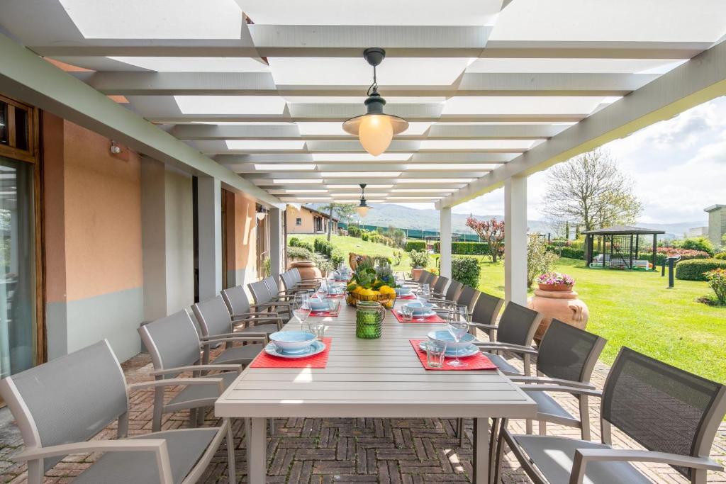 - une grande table et des chaises blanches sur la terrasse dans l'établissement Villa le Greti 16 by VacaVilla, à Bibbiena 72 autres photos