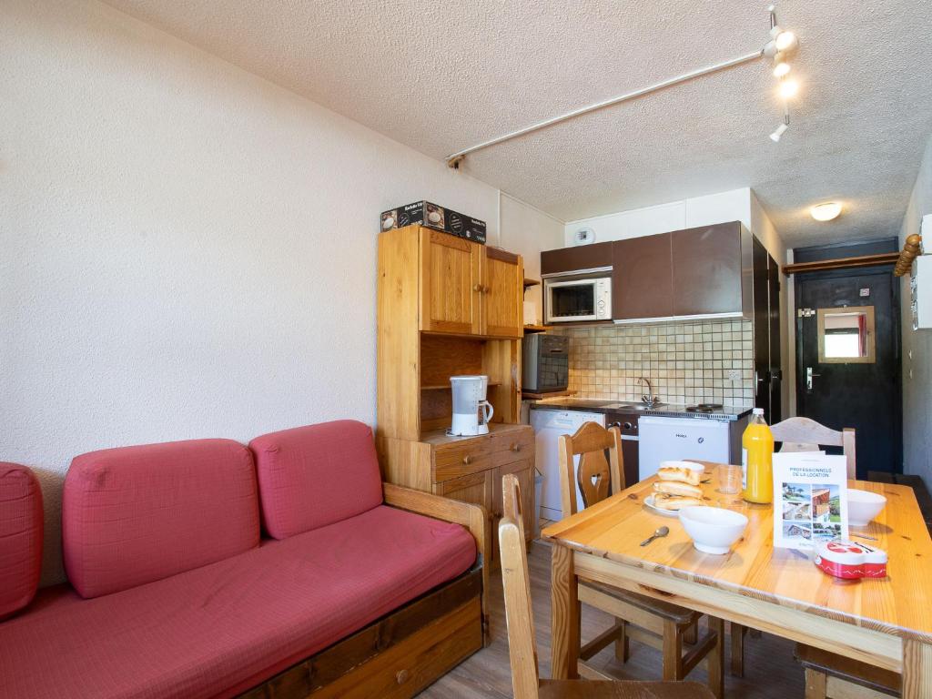 un salon avec un canapé rouge et une table dans l'établissement Apartment Vanoise 152 by Interhome, à Val Thorens