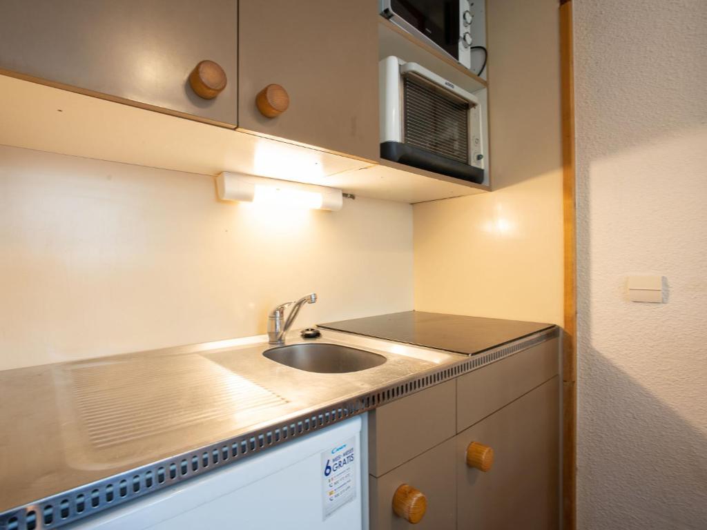 une petite cuisine avec un évier et un micro-ondes dans l'établissement Studio Arcelle 216 by Interhome, à Val Thorens