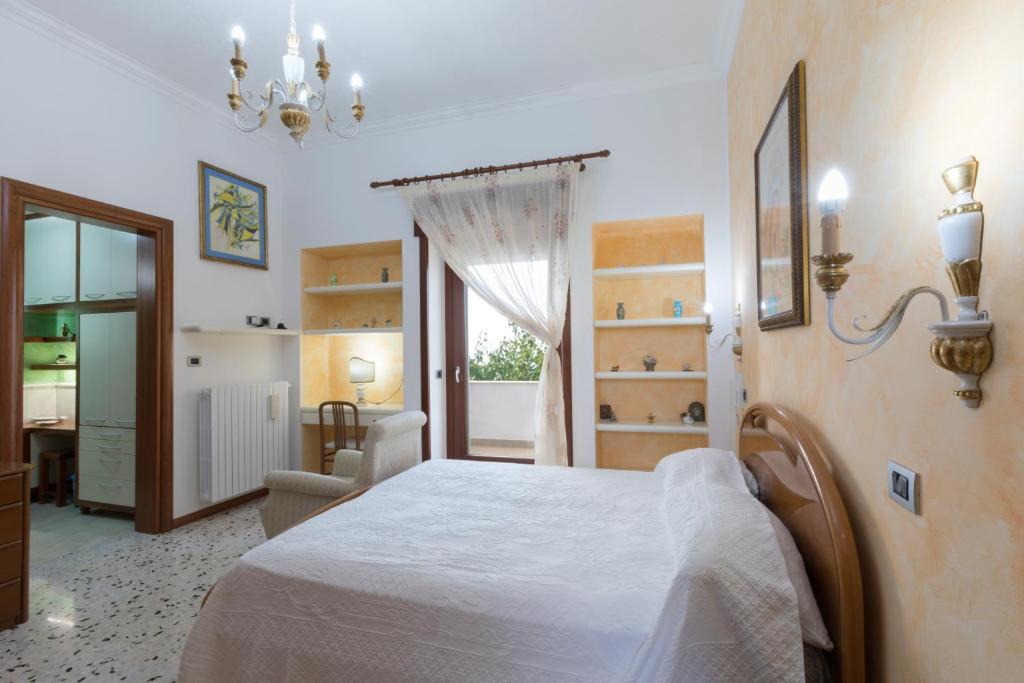 une chambre avec un lit, une chaise et une fenêtre dans l'établissement Villa Eleonora con piscina Fronte Mare, à Capilungo 70 autres photos