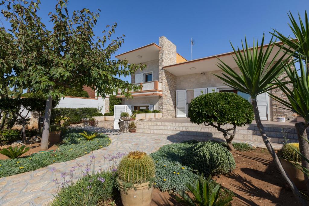 une maison avec un jardin devant dans l'établissement Villa Eleonora con piscina Fronte Mare, à Capilungo