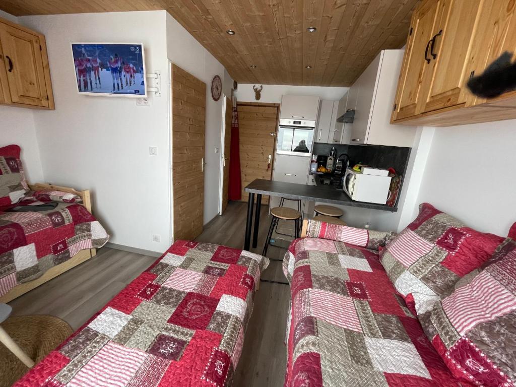 une chambre avec deux lits et une table dans l'établissement residence les Ravieres 1, à La Toussuire