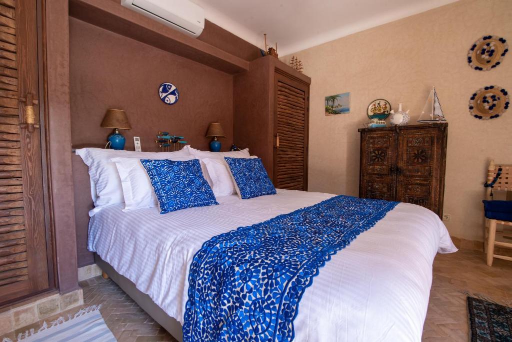 une chambre avec un grand lit avec des oreillers bleus dans l'établissement L’oasis de kima, à Taroudant