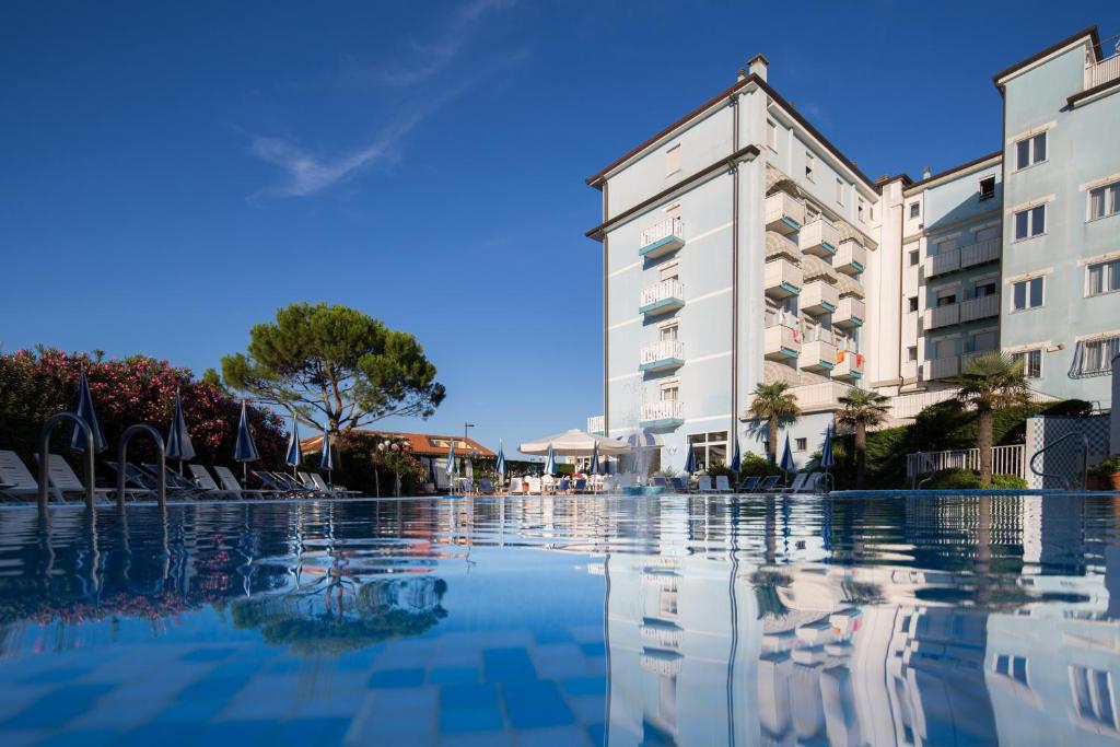 une grande piscine devant un immeuble dans l'établissement Hotel Principe, à Caorle