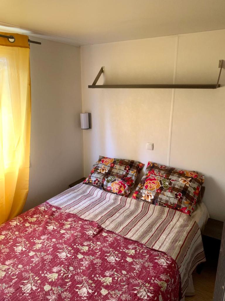 une petite chambre avec un lit avec une couverture rouge dans l'établissement Mobil Home 6 personnes, à Saint-Chéron 10 autres photos