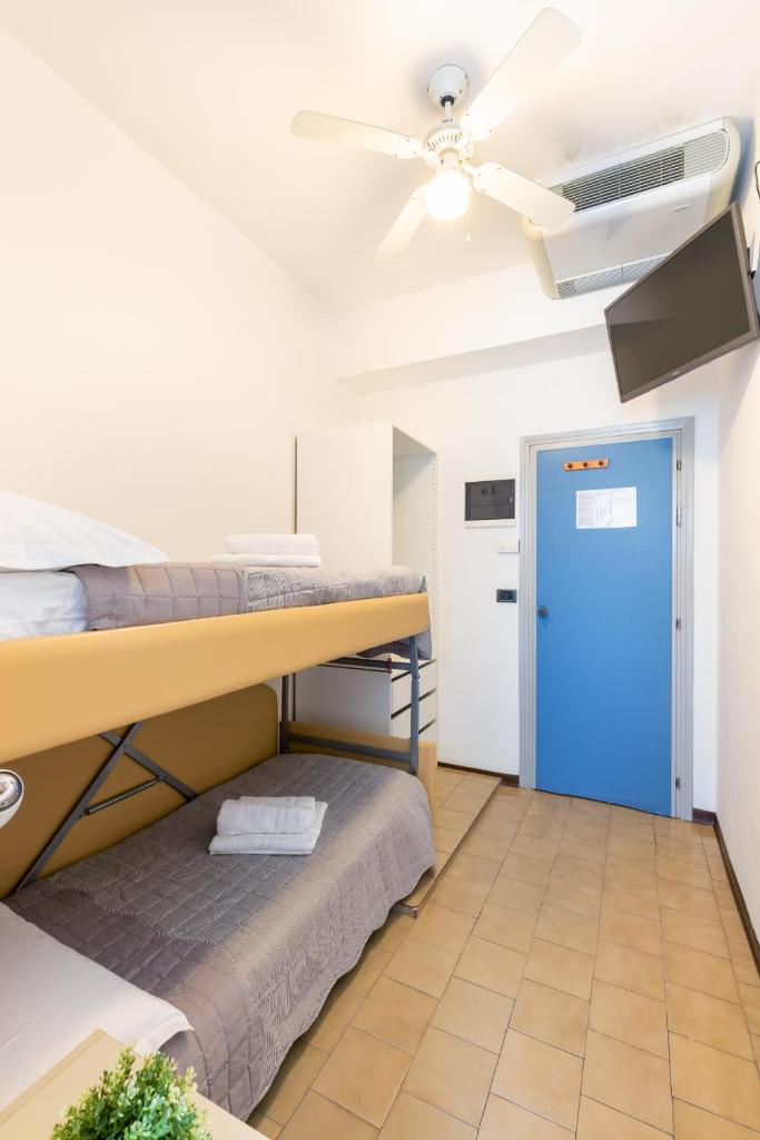 une chambre avec deux lits superposés et un ventilateur de plafond dans l'établissement Hotel Mignon Riccione Fronte Mare, à Riccione