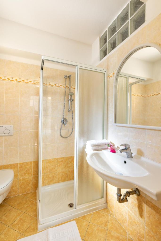une salle de bain avec douche et lavabo dans l'établissement Hotel Mignon Riccione Fronte Mare, à Riccione