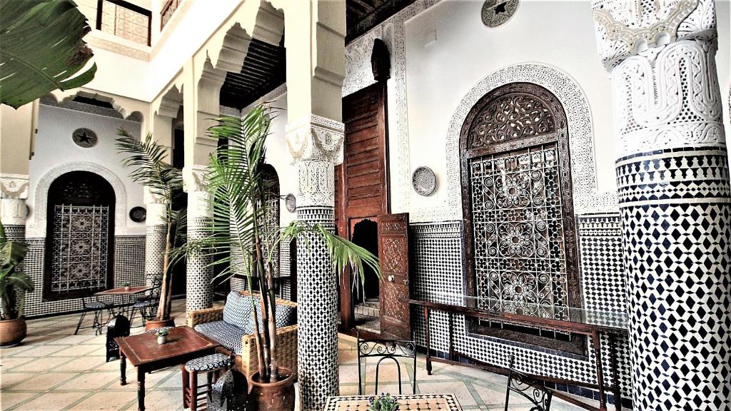 un bâtiment avec une grande porte, des tables et des chaises dans l'établissement Riad Razane Fez, à Fès