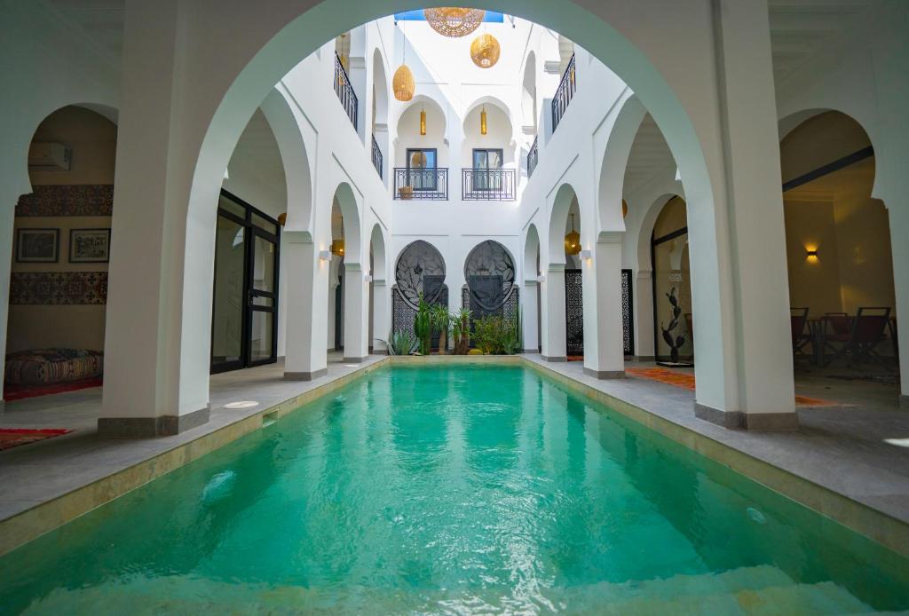 - une piscine intérieure dans un bâtiment avec une arche dans l'établissement Riad Shanima SPA Marrakech, à Marrakech
