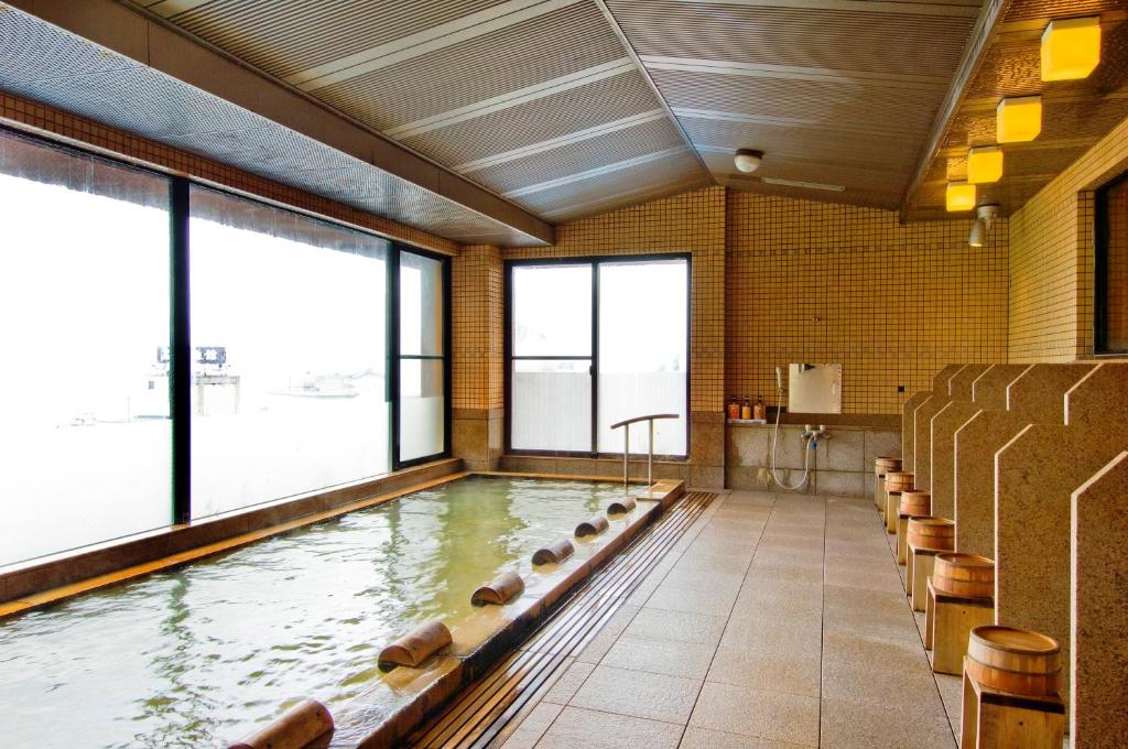 - une piscine avec des chaises dans une grande pièce dans l'établissement Kishigon Ryokan, à Shibukawa