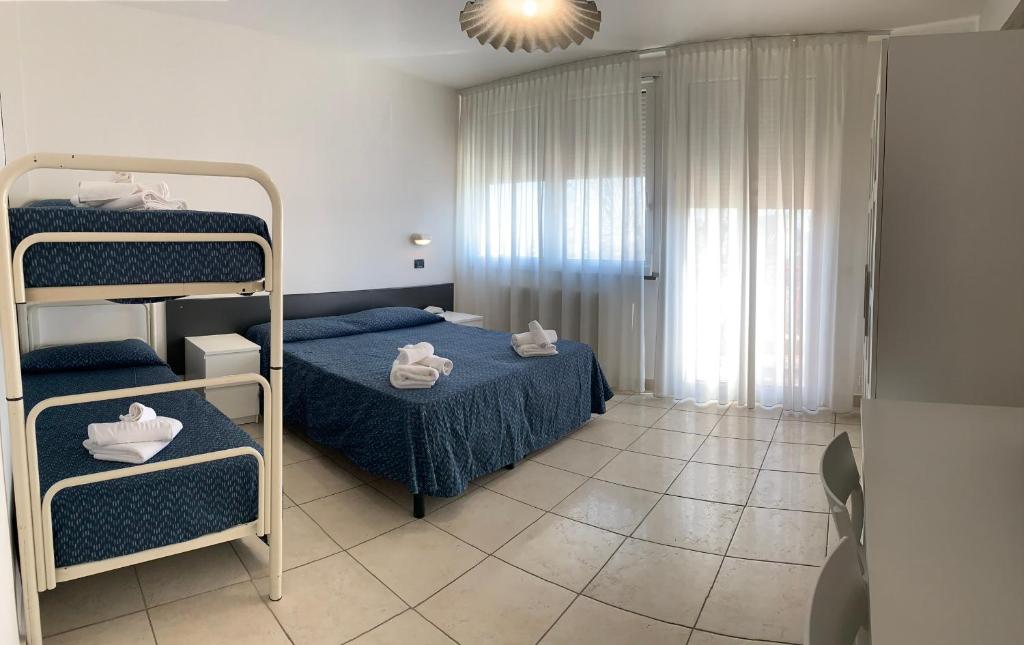 une chambre avec deux lits superposés et un lit bleu dans l'établissement Hotel Marylise, à Rimini
