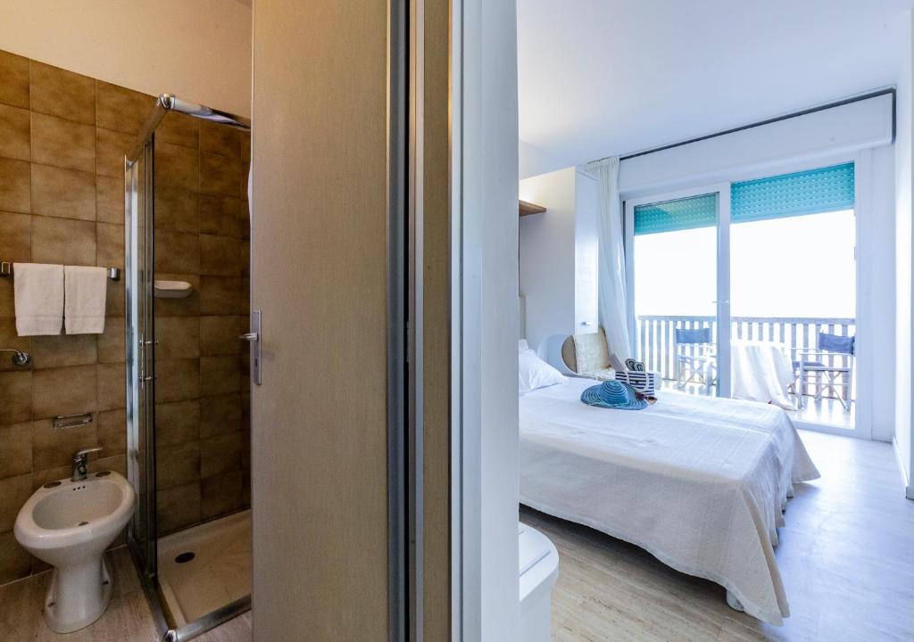 Cet appartement comprend une chambre avec un lit et une salle de bains avec un balcon. dans l'établissement Eurhotel, à Rimini