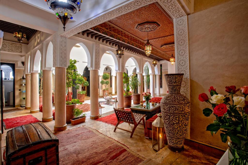 un grand hall avec une table et un vase dans l'établissement Riad Basim, à Marrakech