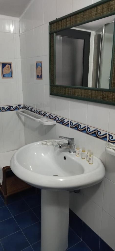 une salle de bain avec un lavabo blanc et un miroir dans l'établissement MOOD Sea Stage, à Castiglione