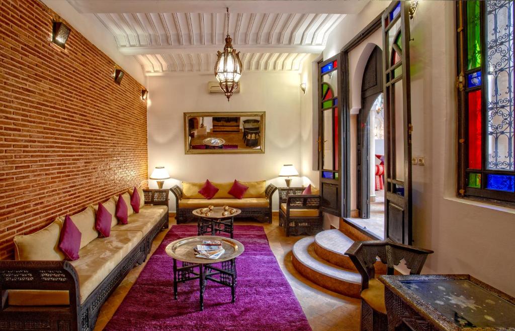 un salon avec un canapé et un mur de briques dans l'établissement Riad Basim, à Marrakech