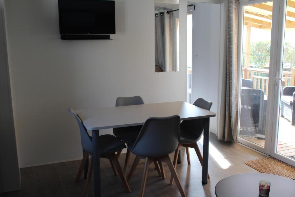 une table à manger avec des chaises et une télévision dans l'établissement Vos meilleures vacances au Montourey!, à Fréjus