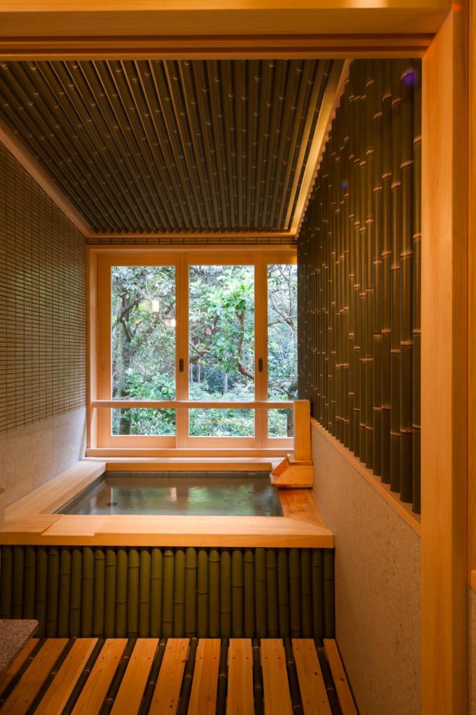 une baignoire jacuzzi dans une chambre avec fenêtre dans l'établissement Ikyu, à Ise 30 autres photos