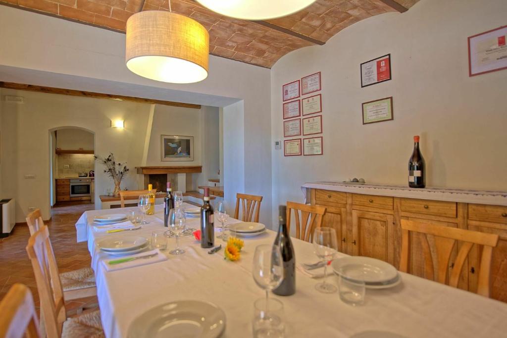 - une salle à manger avec une table, des verres et des bouteilles de vin dans l'établissement Villa Panizzi by PosarelliVillas, à San Gimignano
