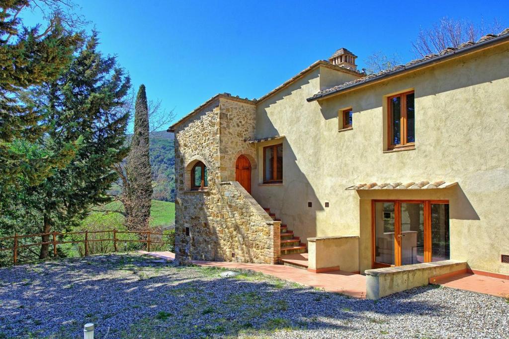 une grande maison en pierre avec un portail et une cour dans l'établissement Villa Panizzi by PosarelliVillas, à San Gimignano